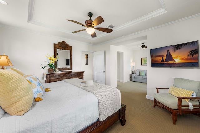 carpeted bedroom featuring ceiling fan, crown molding, and a tray ceiling