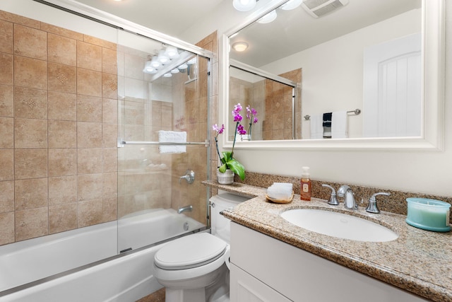 full bathroom with vanity, toilet, and enclosed tub / shower combo