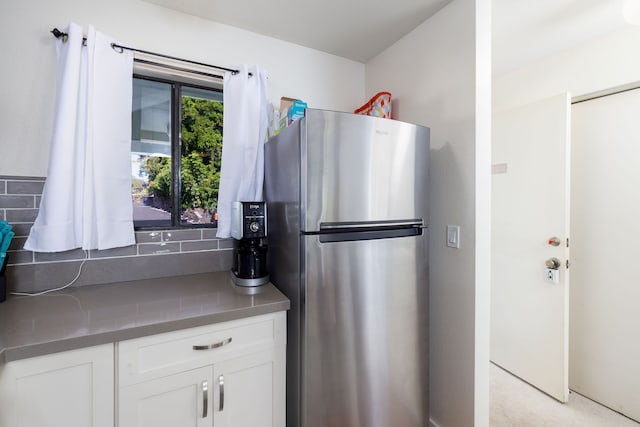 kitchen with light carpet, stainless steel fridge, and white cabinets