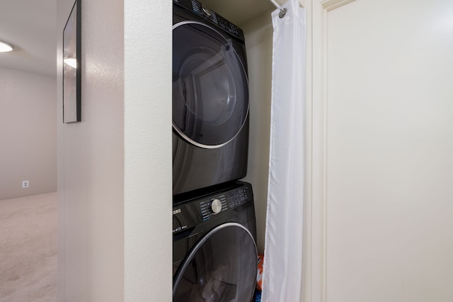 washroom featuring carpet floors and stacked washer and clothes dryer