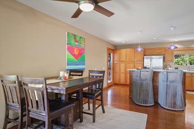 dining space featuring light hardwood / wood-style flooring, ceiling fan, and sink