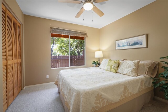 bedroom featuring ceiling fan, a closet, and light carpet