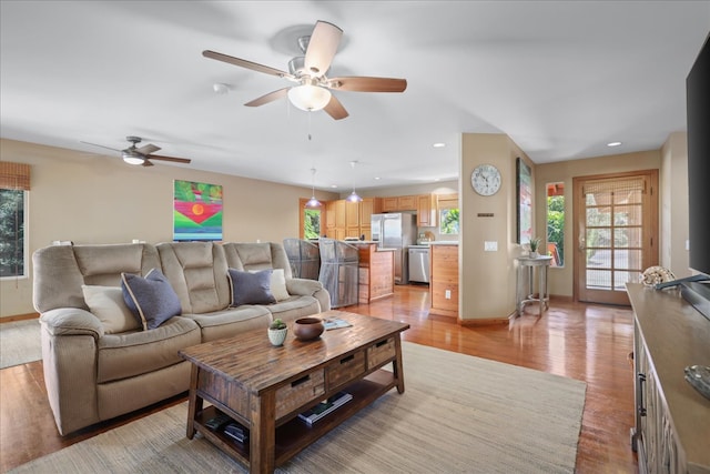 living room with light hardwood / wood-style flooring and ceiling fan