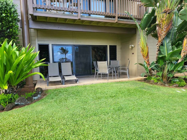 back of house with a lawn, a patio, and a balcony