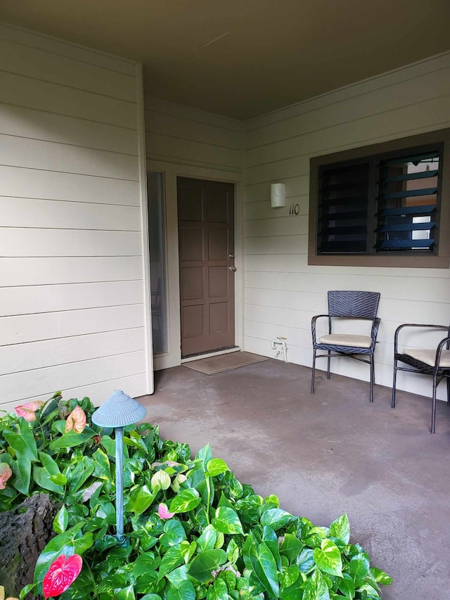 view of exterior entry with a patio area