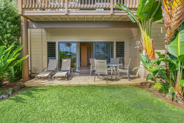 back of house featuring a yard, a patio, and a balcony