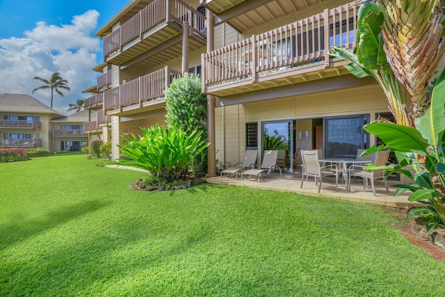 back of property with a yard and a patio