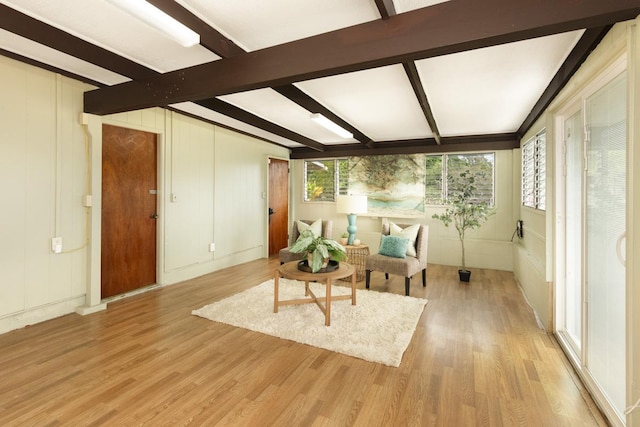 living room featuring beamed ceiling and light wood-type flooring