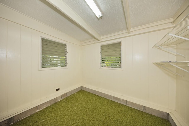 carpeted spare room with beamed ceiling and a textured ceiling