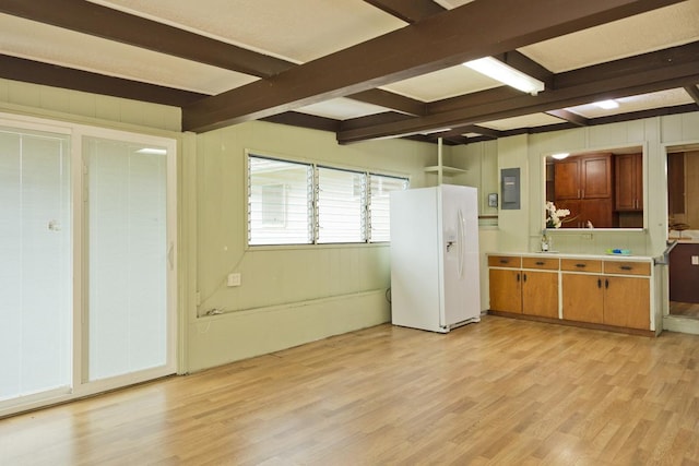 kitchen with beam ceiling, white fridge with ice dispenser, electric panel, and light wood-type flooring