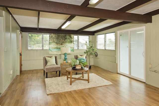 sitting room featuring a healthy amount of sunlight, vaulted ceiling with beams, and light hardwood / wood-style flooring