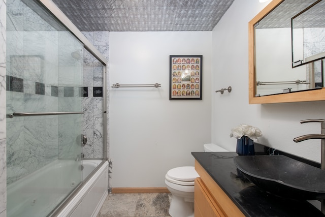 full bathroom with vanity, enclosed tub / shower combo, and toilet