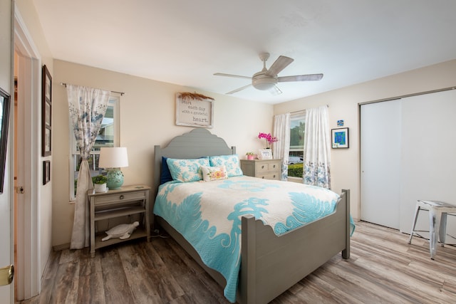 bedroom featuring ceiling fan, a closet, and hardwood / wood-style flooring