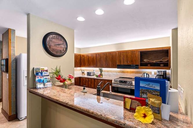 kitchen with light stone counters, sink, ventilation hood, and electric stove