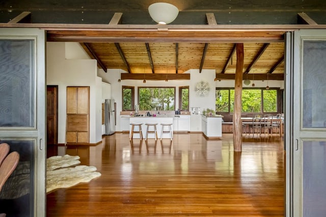 sunroom / solarium featuring lofted ceiling with beams and wood ceiling