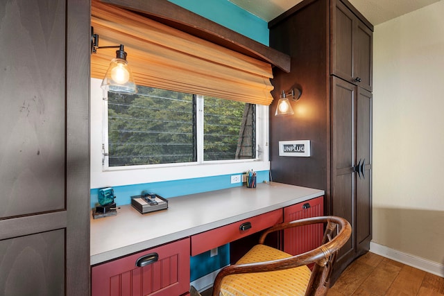 home office with a textured ceiling and light hardwood / wood-style flooring