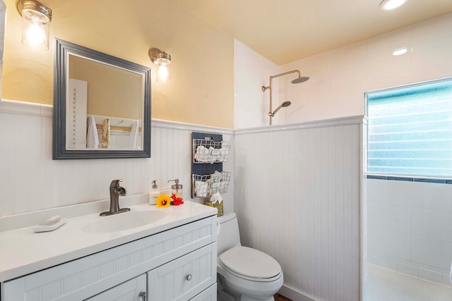 bathroom featuring tiled shower, vanity, and toilet