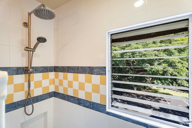 bathroom featuring a tile shower and a healthy amount of sunlight