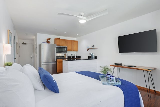 bedroom featuring dark wood-type flooring, sink, stainless steel refrigerator, and ceiling fan