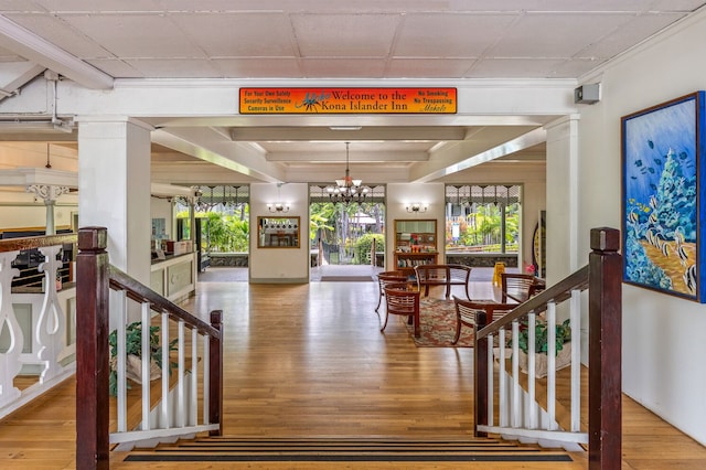 interior space featuring hardwood / wood-style floors, decorative columns, and a notable chandelier