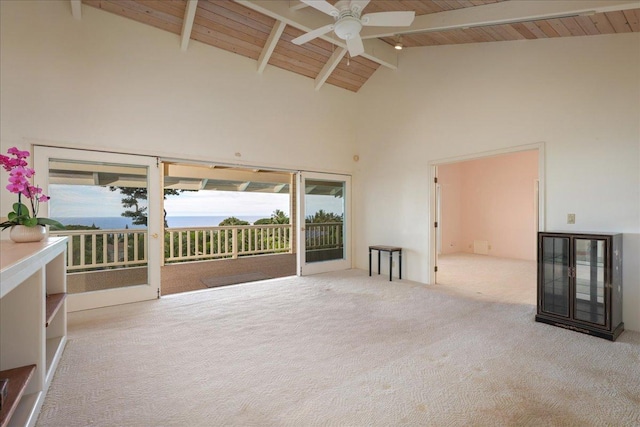 empty room with light carpet, high vaulted ceiling, a wealth of natural light, and beamed ceiling