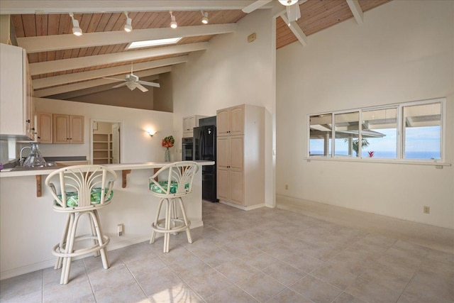 kitchen featuring ceiling fan, a kitchen bar, kitchen peninsula, and wooden ceiling