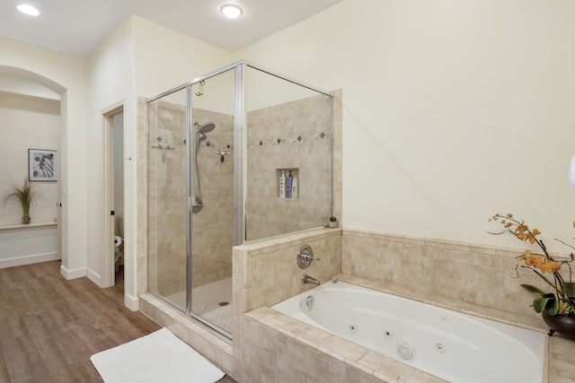 bathroom featuring toilet, hardwood / wood-style floors, and separate shower and tub