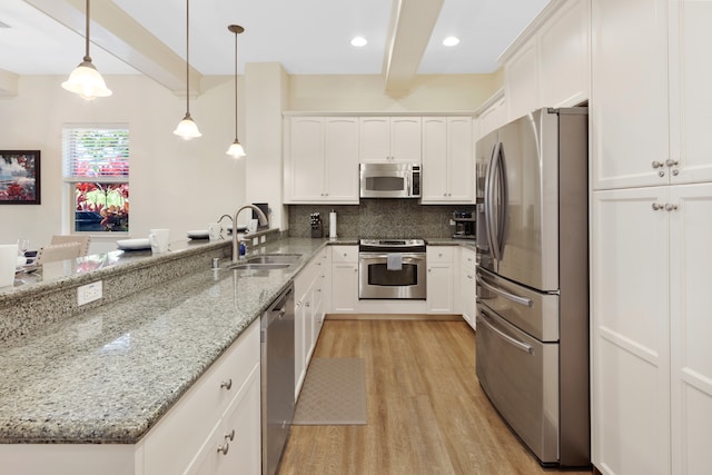 kitchen featuring white cabinetry, appliances with stainless steel finishes, decorative light fixtures, sink, and beamed ceiling