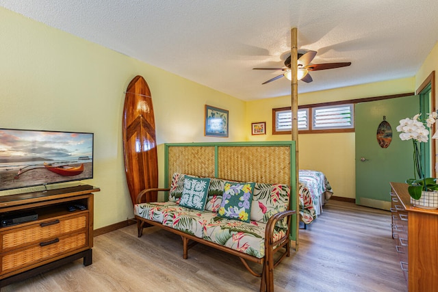 bedroom featuring ceiling fan, light hardwood / wood-style flooring, and a textured ceiling