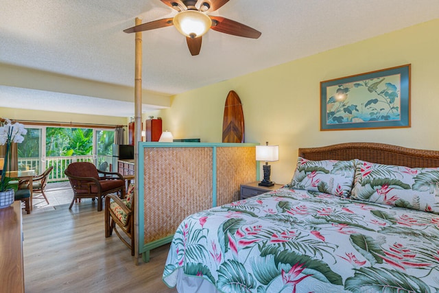 bedroom with ceiling fan, hardwood / wood-style floors, and a textured ceiling