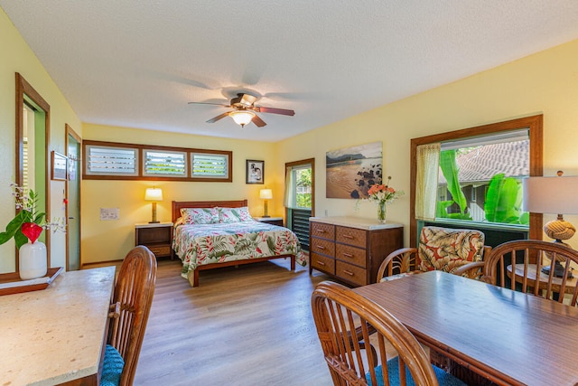 bedroom featuring ceiling fan, a textured ceiling, and multiple windows