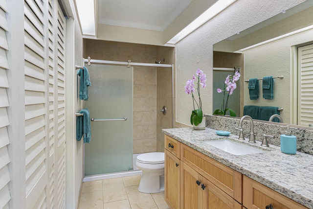 bathroom with vanity, tile patterned floors, crown molding, toilet, and a shower with shower door