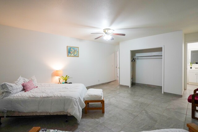 bedroom featuring ceiling fan, ensuite bath, and a closet