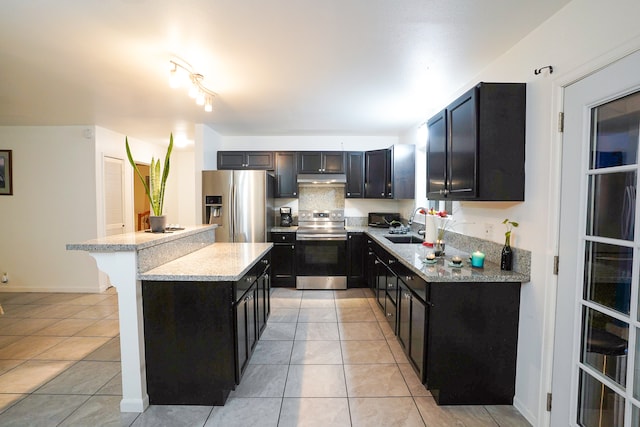 kitchen featuring a kitchen breakfast bar, appliances with stainless steel finishes, light tile patterned floors, and a center island