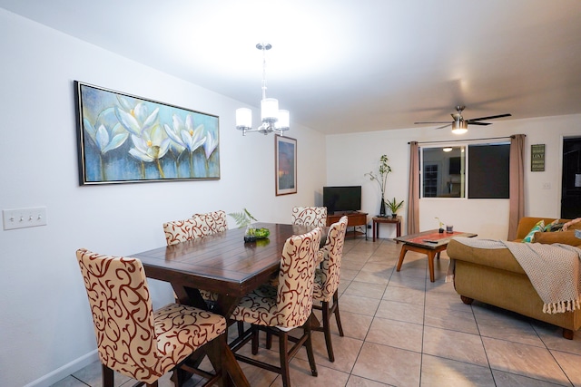 tiled dining area with ceiling fan with notable chandelier