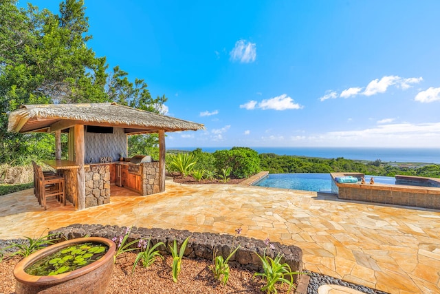 view of swimming pool with an outdoor bar, a water view, area for grilling, and a patio area