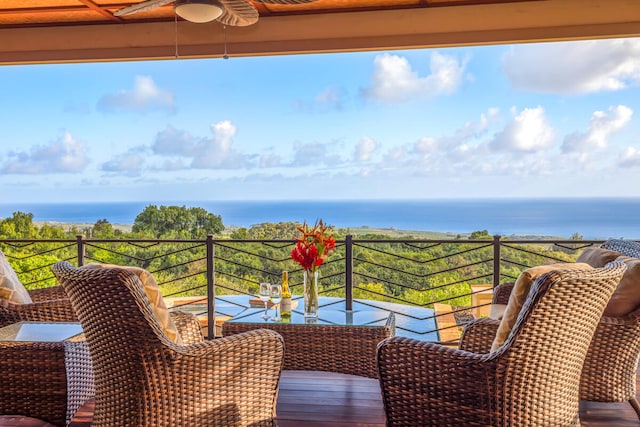 balcony with a water view and ceiling fan