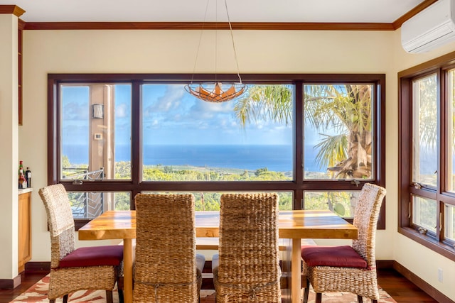 dining area with dark wood-type flooring, a water view, crown molding, a wall mounted AC, and a chandelier