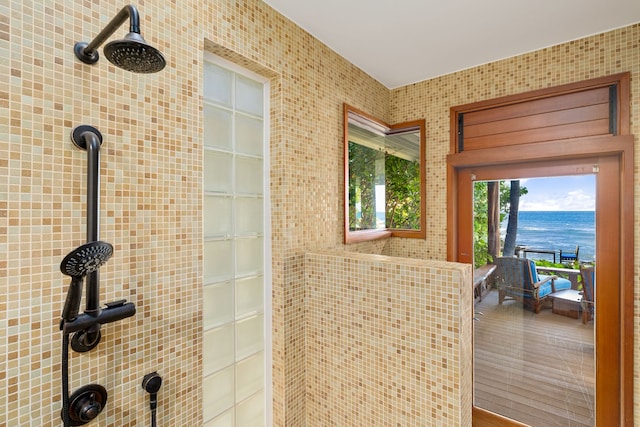 bathroom with a shower, hardwood / wood-style floors, a water view, and tile walls