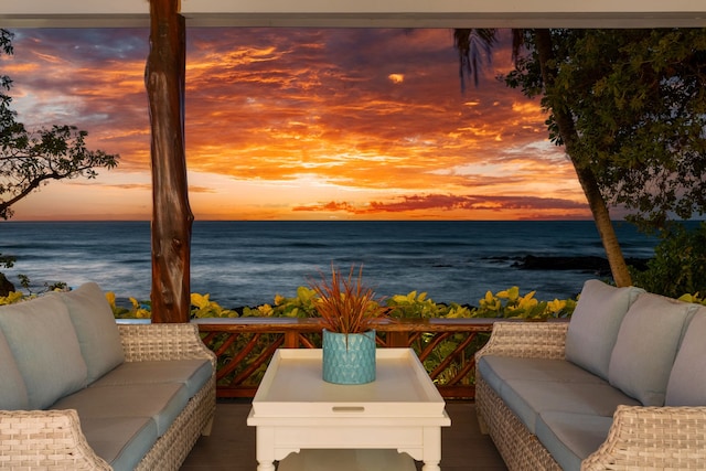 balcony at dusk featuring a water view and an outdoor hangout area