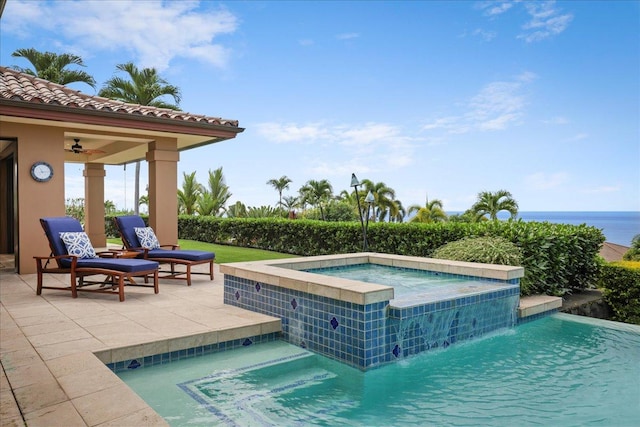 view of pool with an in ground hot tub, pool water feature, and a water view