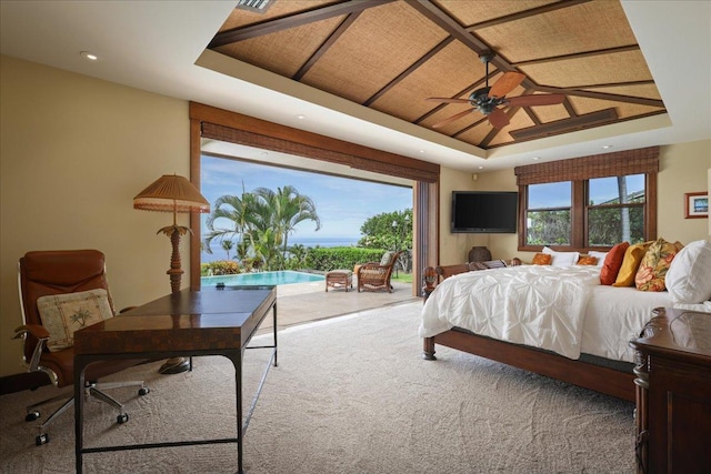 bedroom featuring carpet floors, a tray ceiling, and ceiling fan