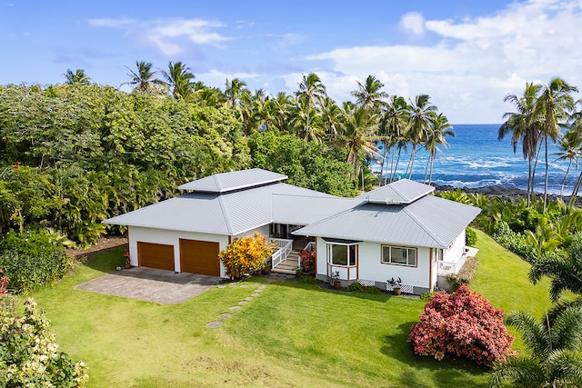 view of front of home with a garage, a water view, and a front yard