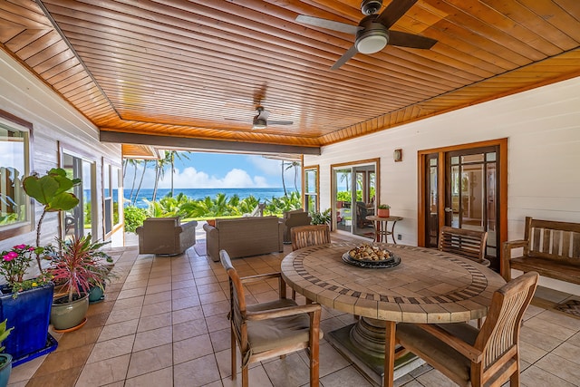 sunroom featuring a water view, ceiling fan, and wooden ceiling