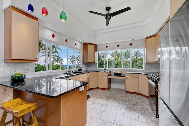 kitchen with pendant lighting, a kitchen breakfast bar, stainless steel fridge, and plenty of natural light