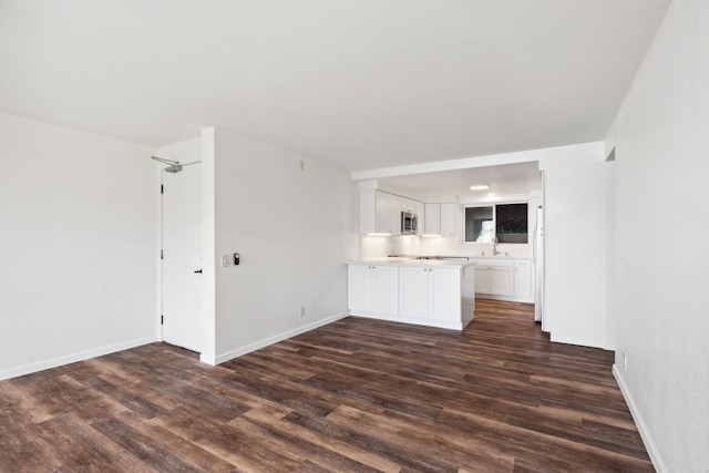 unfurnished living room with sink and dark hardwood / wood-style floors