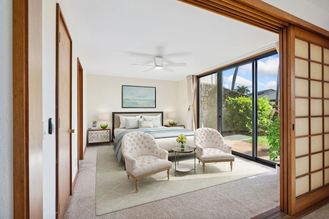 carpeted bedroom featuring ceiling fan, expansive windows, and access to exterior