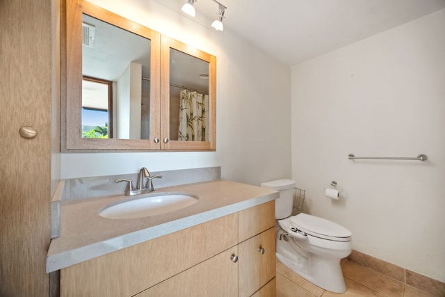 bathroom featuring tile patterned flooring, vanity, and toilet