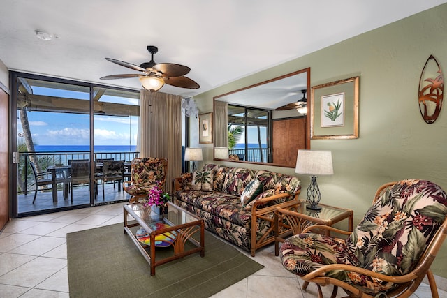 living room with ceiling fan, a healthy amount of sunlight, and a water view