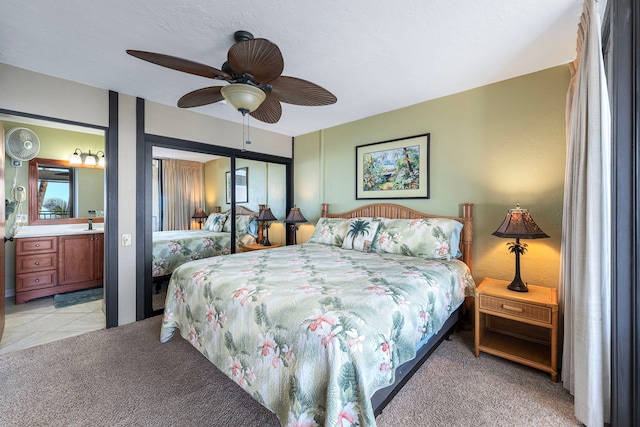 carpeted bedroom with ceiling fan and ensuite bath